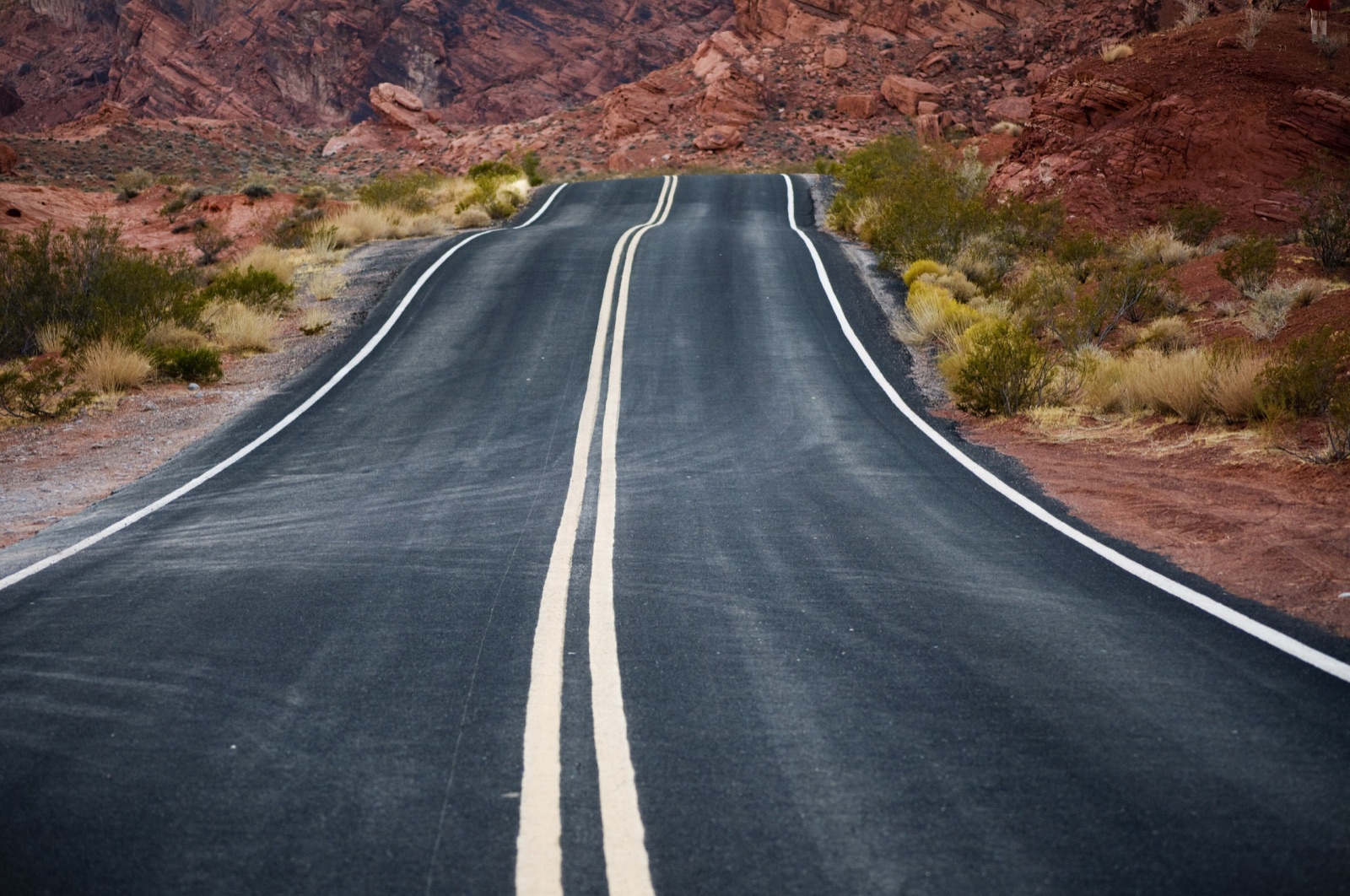 Two-lane desert highway through red sandstone at Valley of Fire, southern Nevada